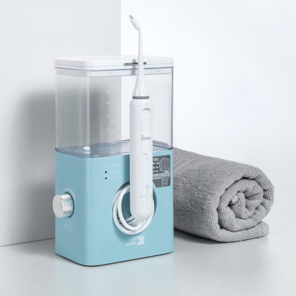edel+white Flosserpik Pro Station – leistungsstarke Munddusche mit 10 Druckstufen, 2 Modi und 4 Aufsätzen für gründliche Zahn- und Zahnfleischpflege. Abbildung Produkt mit Handtuch nebenan.