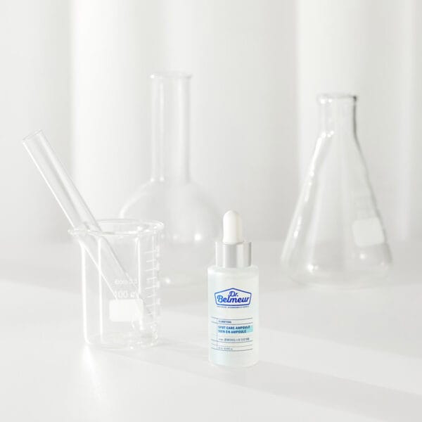 Dr. Belmeur Spot Care Ampoule 22ml - soothing serum with panthenol, beta-glucan, chaga mushroom and tea tree oil against blemishes and redness. Image of product with test tubes in the background. 