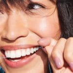 REACH POP dental floss mint - vegan, waxed dental floss with 384 micro threads & sustainable packaging, 50m. Picture dental floss in action. 