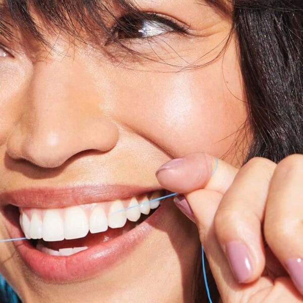 REACH POP dental floss mint - vegan, waxed dental floss with 384 micro threads & sustainable packaging, 50m. Picture dental floss in action. 